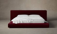 a red bed with white sheets and pillows