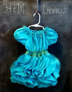 a blue dress hanging on a chalkboard with the words, i am inspired written on it