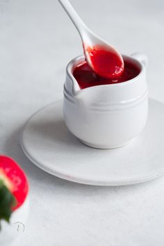 a small white bowl filled with strawberry jam