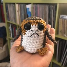 a crocheted stuffed animal is in the palm of someone's hand