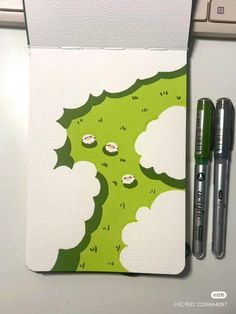 two pens sitting on top of a green and white notebook