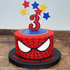 a spiderman birthday cake with stars and the number three on it's top