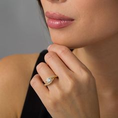 a woman wearing a gold ring with a diamond on the middle and a side view of her face