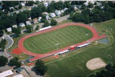 an aerial view of a soccer field and the surrounding area is green with red markings