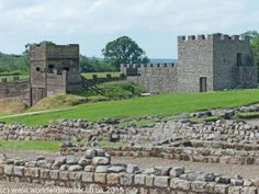 an old stone castle sitting on top of a lush green field