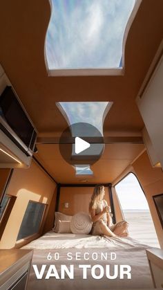 a woman sitting on top of a bed in a room with skylights above it