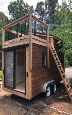 a tiny house with a ladder going up the side