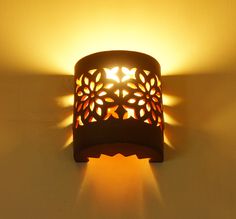 a light that is on the side of a wall with a flower pattern on it