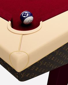 a billiard's table with a ball on it and a red velvet cover