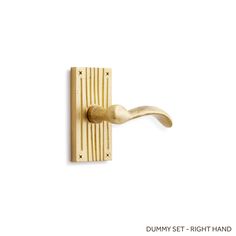 a wooden door handle that is on the side of a white wall and has a gold finish