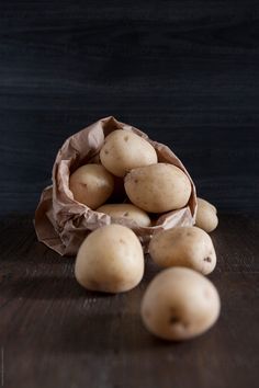 potatoes in a paper bag on a wooden table