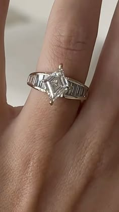 a woman's hand with a diamond ring on it