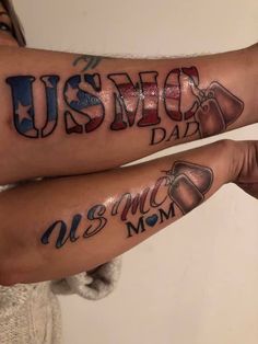 two people with matching tattoos on their arms, one has the word us and the other says