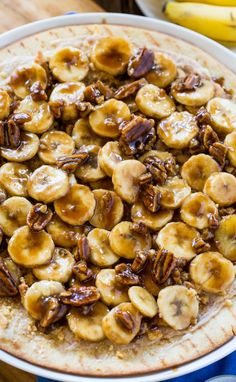 a plate filled with bananas and pecans on top of a table