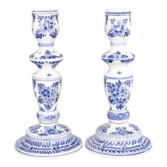 two blue and white candlesticks sitting next to each other