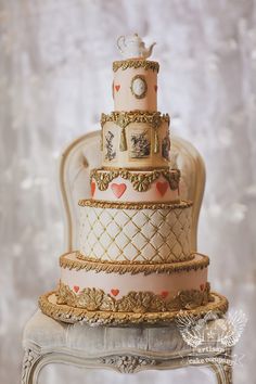 a three tiered cake sitting on top of a white table next to a chair