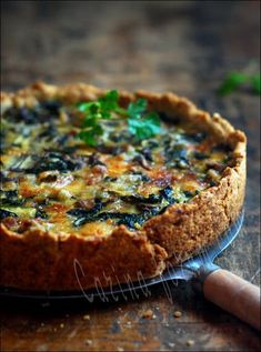 a quiche with cheese and spinach on a wooden table