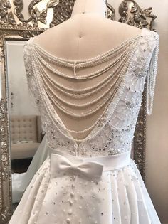 the back of a wedding dress with pearls on it