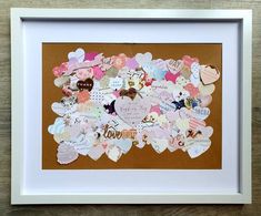 a white frame filled with lots of different types of heart shaped stickers on top of a wooden table