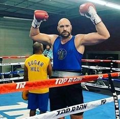 a man standing in a boxing ring with his hands up