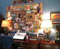 a desk with a lamp and pictures on the wall