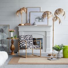 a living room with white walls and gold accents on the fireplace mantel, zebra print chair, palm trees, and other decor