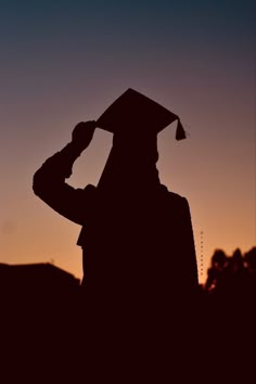 the silhouette of a person wearing a graduation cap