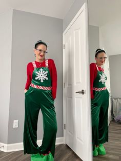 two women dressed in green and red standing next to each other near a white door