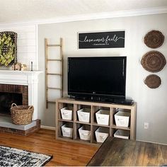 a flat screen tv sitting on top of a wooden shelf next to a fire place