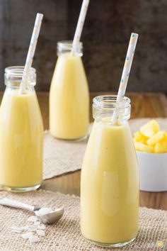 three jars filled with yellow liquid on top of a table