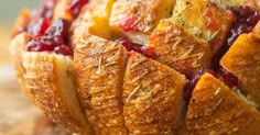 bread with cranberry sauce and herbs cut into pieces on a cutting board, ready to be eaten