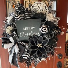 a merry christmas wreath with black and white decorations