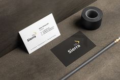 there is a black and white business card next to a roll of tape on the table