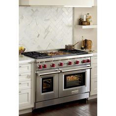 a stainless steel stove with two ovens in the middle of a white kitchen countertop