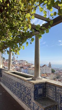 an outdoor seating area with blue and white tiles on the wall, overlooking cityscape