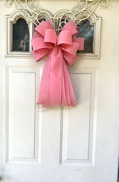 a pink bow hangs on the front door