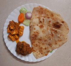 a paper plate topped with different types of food next to carrots and celery