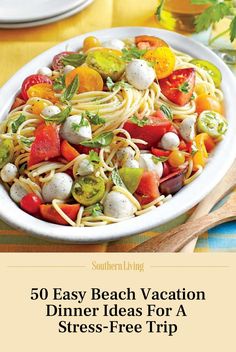 a white bowl filled with pasta and veggies on top of a wooden table