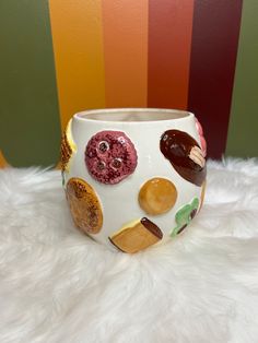 a white vase with different designs on it sitting on top of a furnishing