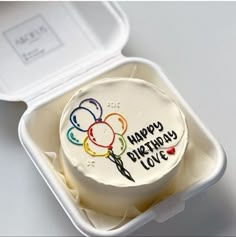 a birthday cake in a plastic container with the lid open to show it's frosting