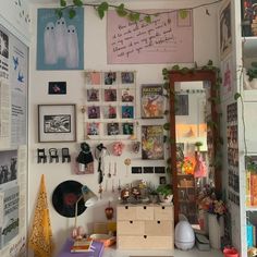 a room filled with lots of clutter and pictures hanging on the wall next to a mirror