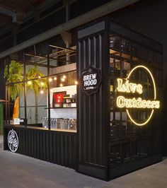 the outside of a restaurant with neon signs and lights on it's side wall