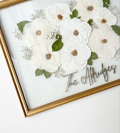 there is a framed picture with flowers on it that says the alleggies in cursive writing