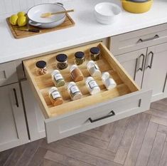 an open drawer in the middle of a kitchen with spices and condiments on it