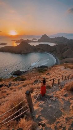 a person sitting on top of a hill near the ocean