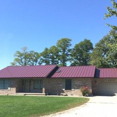 a brick house with a red metal roof