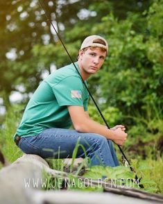 a man squatting on the ground while holding a fishing pole