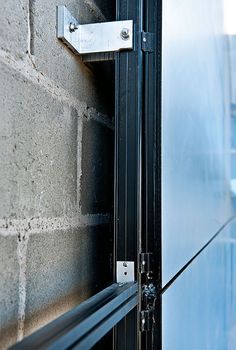 an open door on the side of a brick building with metal bars attached to it