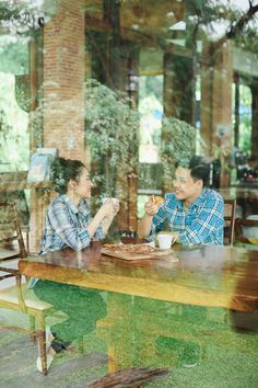 two people sitting at a table eating food