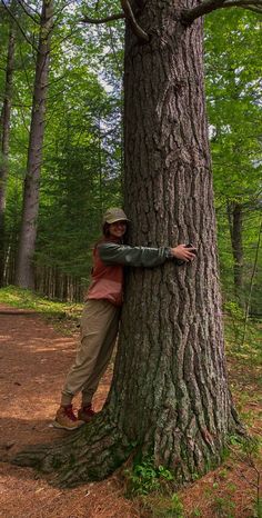 a person hugging a tree in the woods